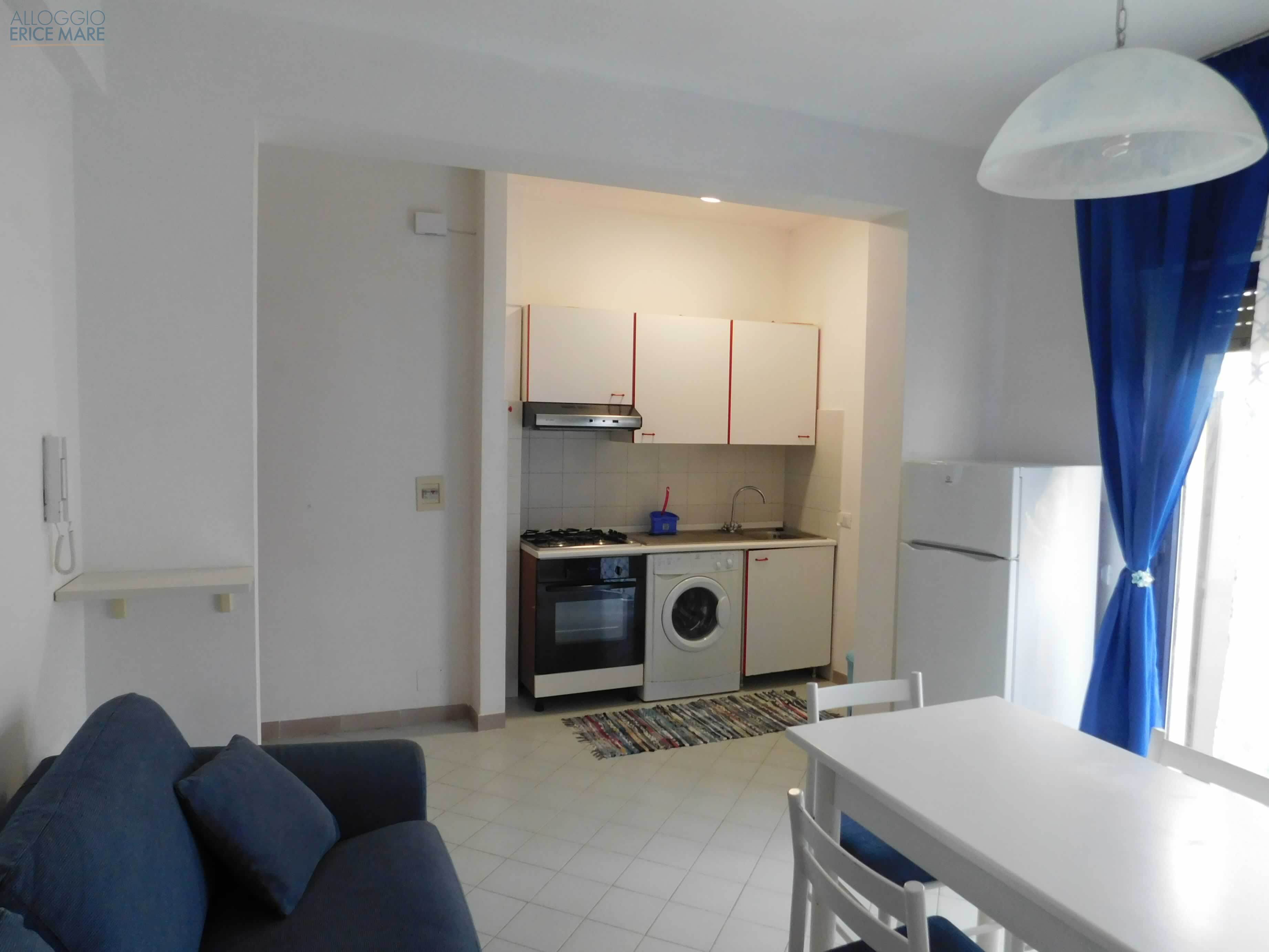 Zona giorno luminosa con tavolo da pranzo e porta-finestra