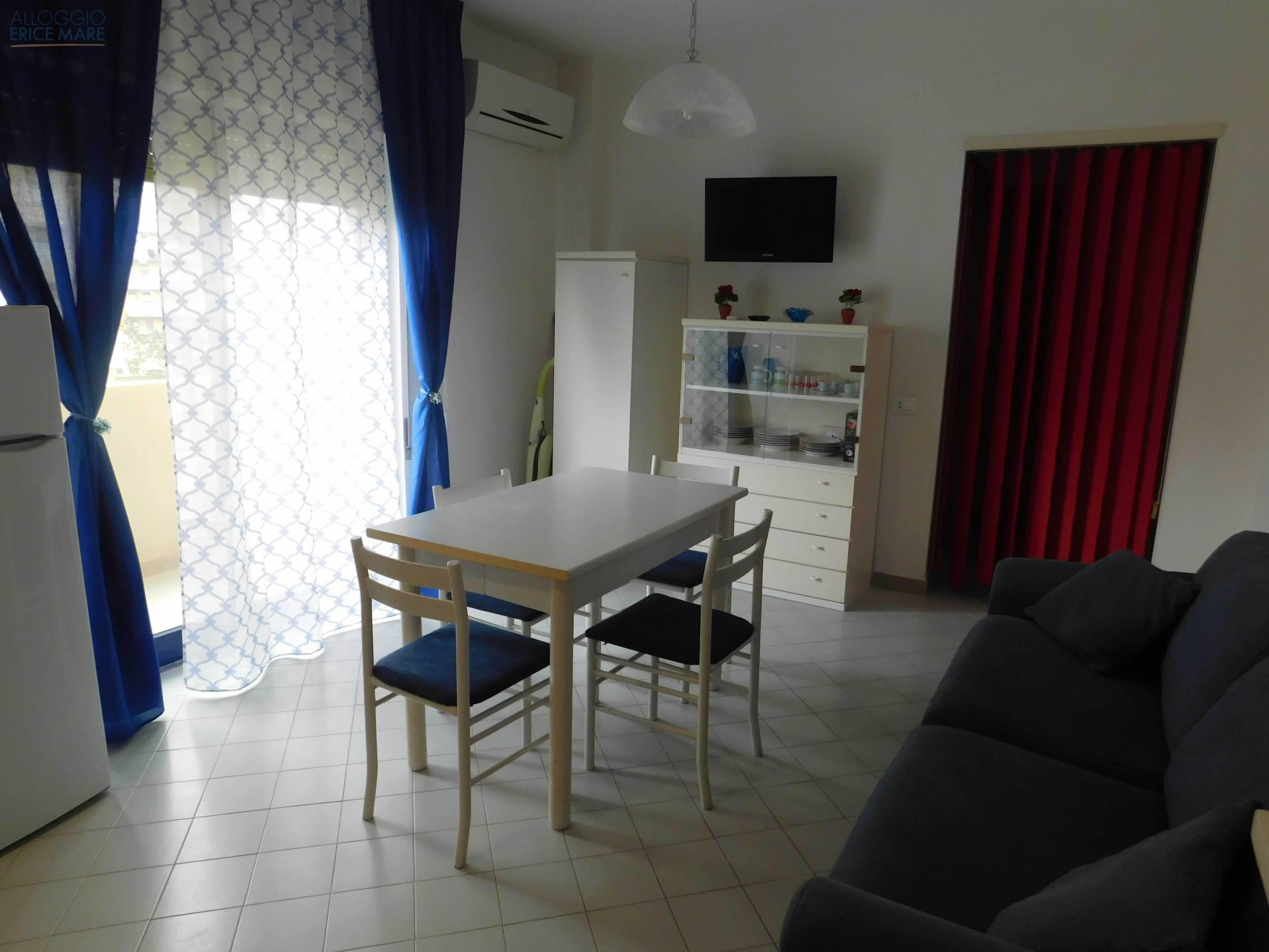 Zona giorno con area salotto e tavolo da pranzo, vista frontale